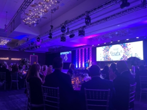 The aad 2022 conference participants are seated at tables in a large room.