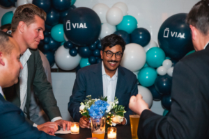 A group of men sitting at a table with balloons during the aad 2022.