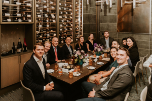 A group of people sitting at a table in a wine cellar during the ASRS 2022 conference.