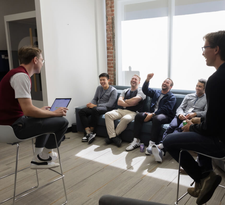 A group of people indulging in careers while sitting on a couch.