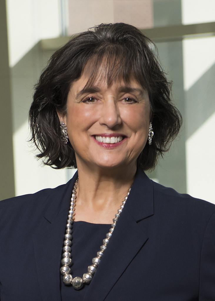 Dr. Roberta Brinton, a woman in a blue suit, smiles for the camera.