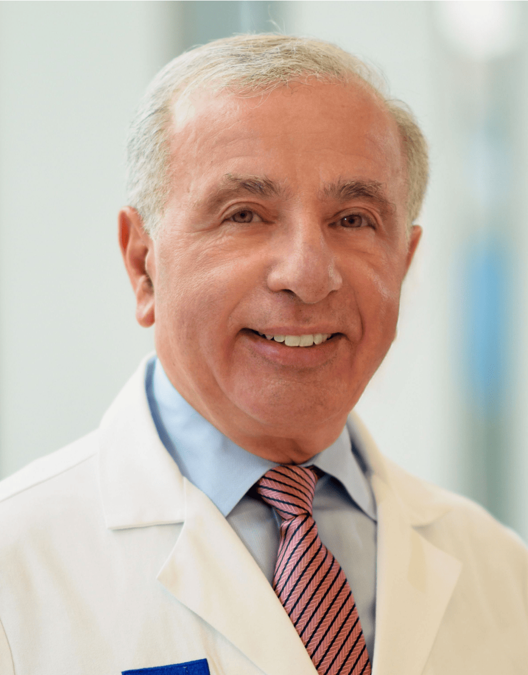 A man in a lab coat, Dr. Joseph Jankovic, smiling for the camera.