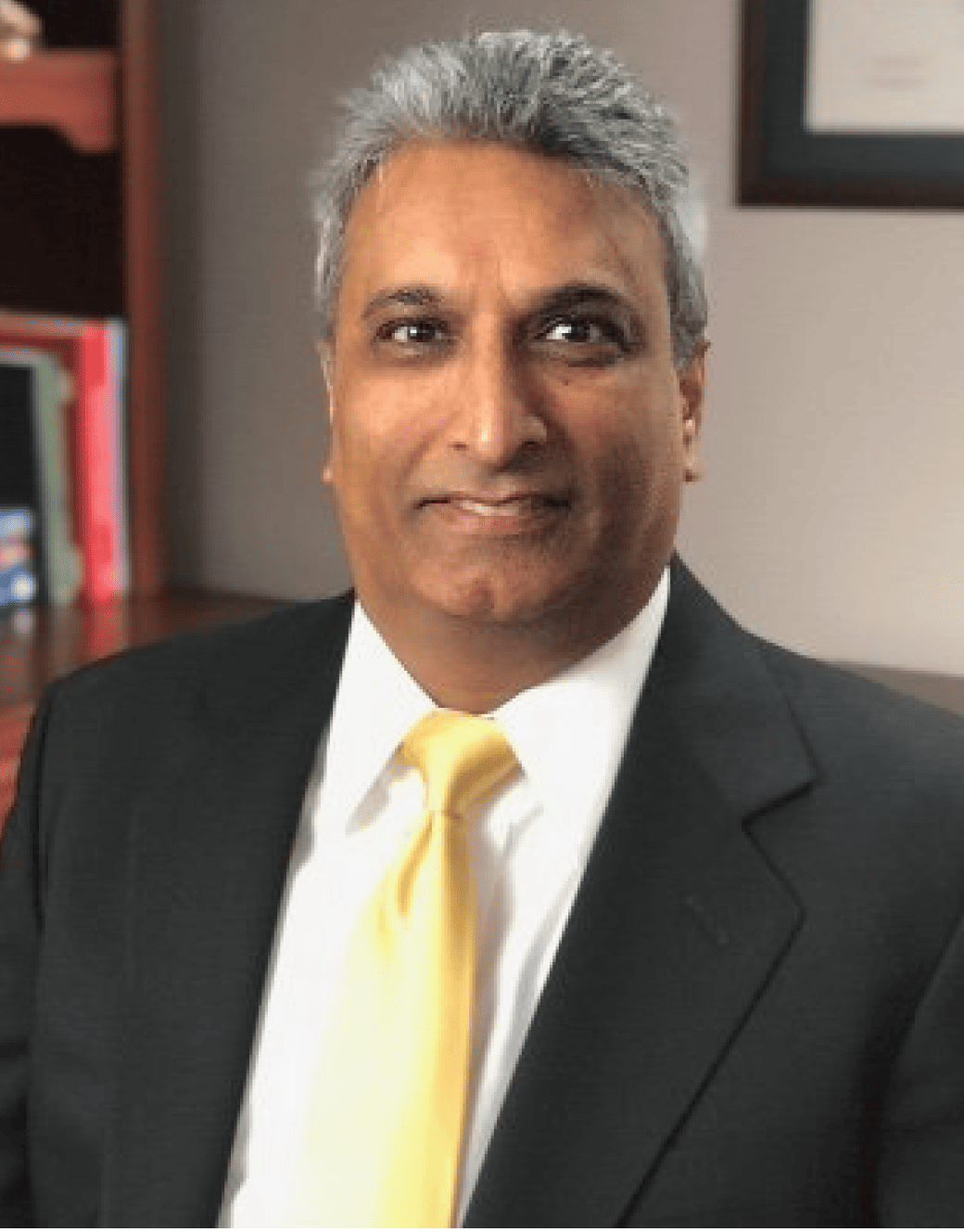 Dr. Rajesh Pahwa, a man in a suit and tie, is posing for a photo.