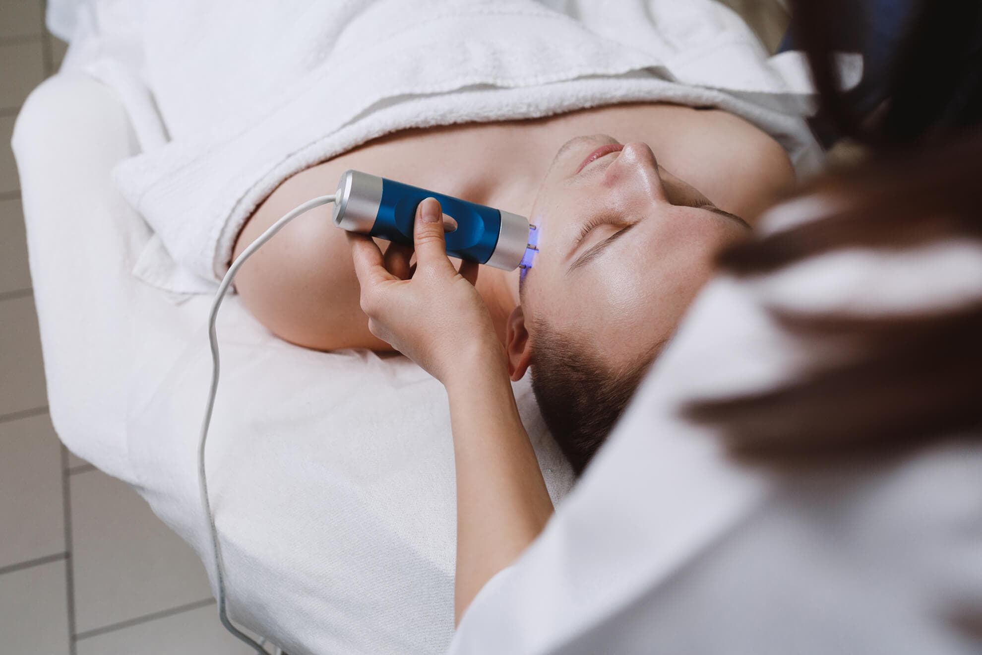 A woman is receiving a dermatology treatment at a spa.