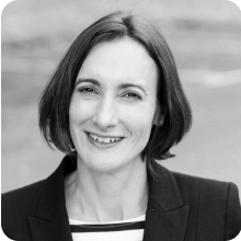 A black and white photo of a woman smiling in a clinical trial.