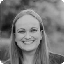 A black and white photo of a woman smiling.