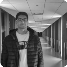 A man standing in a hallway, captured in a black and white photo.