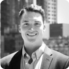 A black and white photo of a smiling man in a suit at ARVO 2023.