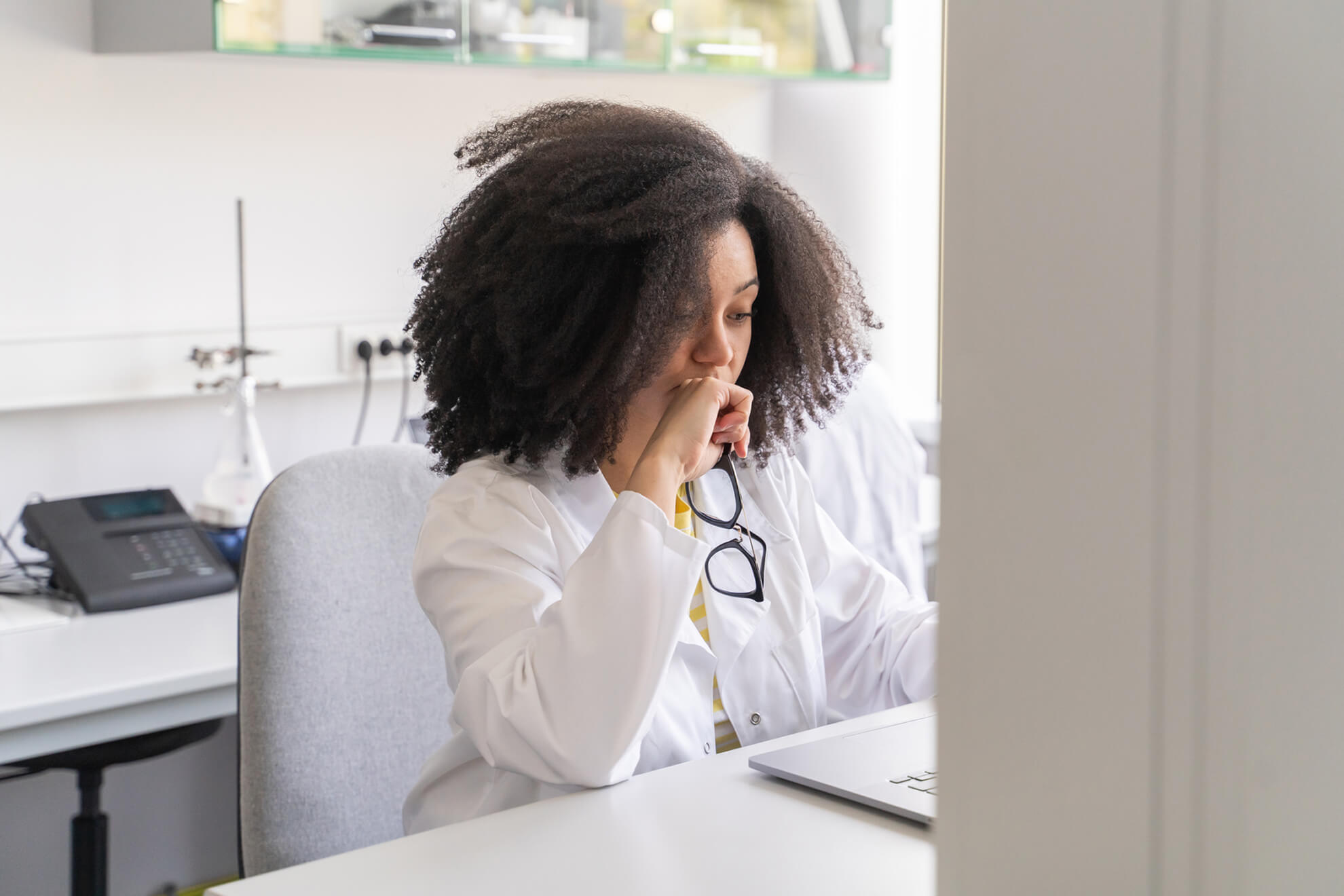 A doctor works in her office, providing medical care and making healthcare decisions to benefit her patients.