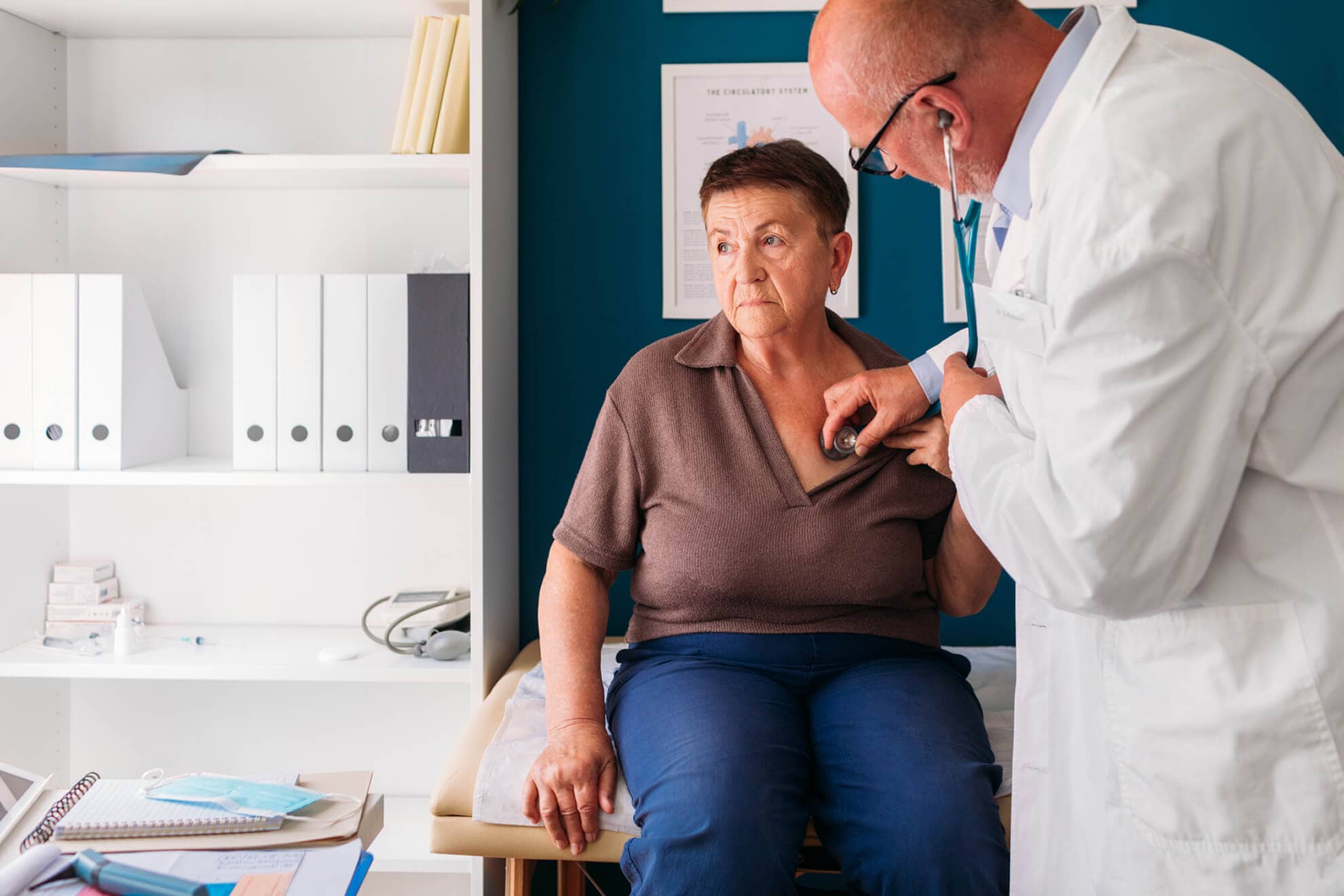 An elderly woman seated in a doctor's office, undergoing a routine checkup and consultation with her dedicated physician.