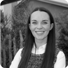 A black and white photo of a woman smiling.