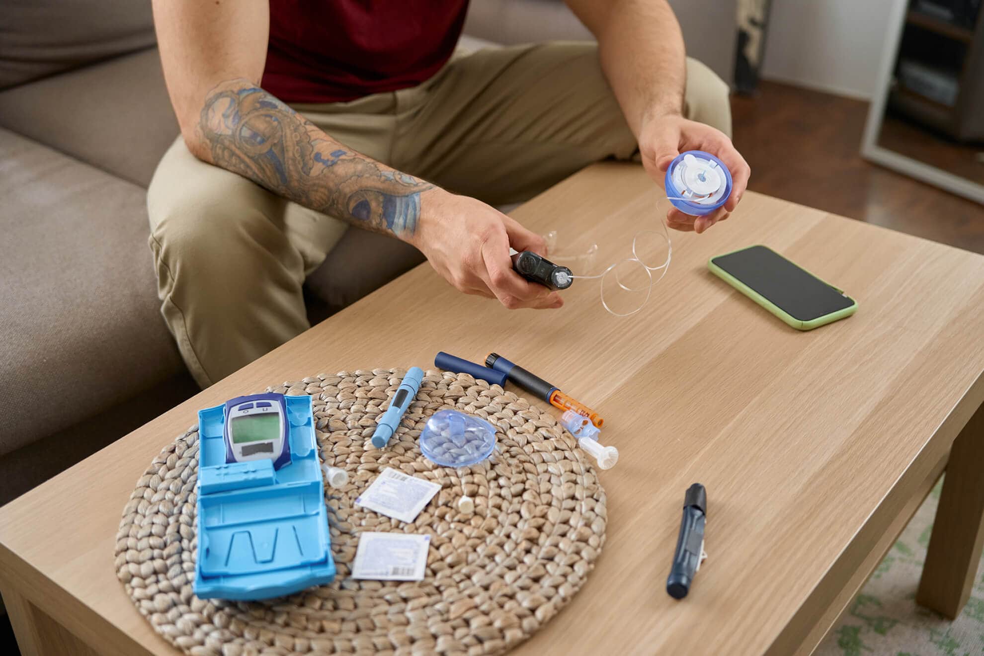 A man with Diabetes Management is sitting on a table with a blood glucose meter.