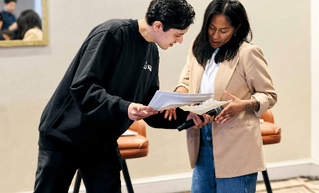 Two people looking at a paper talking.